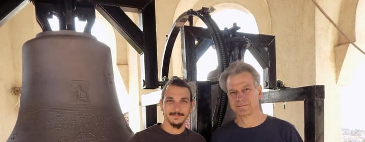 Ο Αργύρης και ο Γιώργος Τσιτούρας σε καμπαναριό, δίπλα σε καμπάνα με χυτή επιγραφή